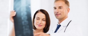 Medical professionals looking at x-ray of spine.