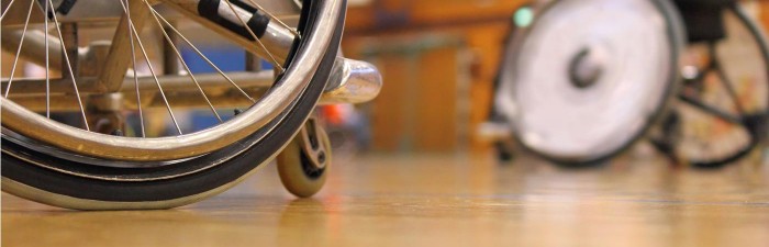 Two men in wheelchairs playing indoor sport